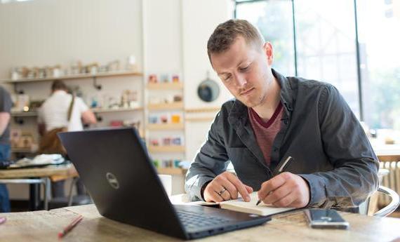 一张专业人士在咖啡店用笔记本电脑工作的照片
