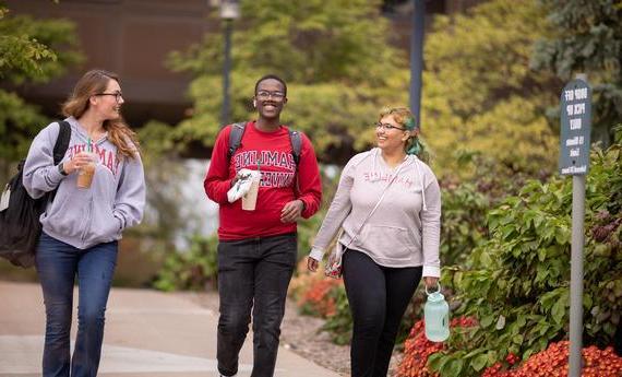 秋天，三个体育博彩app的学生在校园里散步聊天